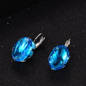 Elegant leverback earrings featuring large faceted blue gems in silver settings