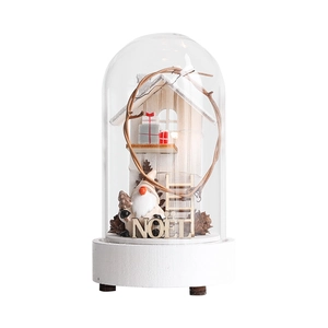 Christmas glass dome decor with gnome and wooden house on a white base with LED lights