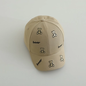 Détail des broderies d'ours et du tissu en coton sur une casquette enfant kaki