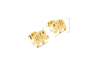 Macro detail of golden elephant earrings with zircon eyes and floral pattern texture