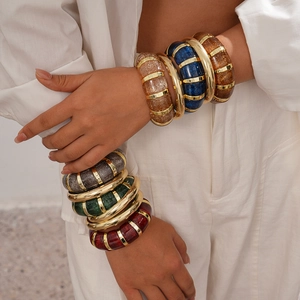 Detail of colorful chunky acrylic bangles with glitter texture and gold vertical stripes