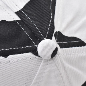 Detailed close-up of cow print cotton baseball cap crown with stitched top button