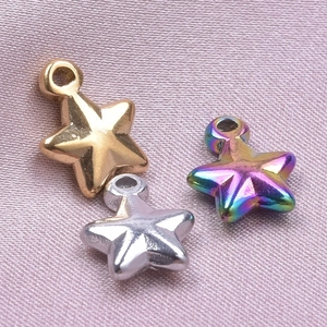 Macro detail of star charms in gold, silver, and rainbow plating on pink silk