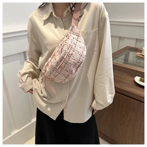 Detailed shot of pink woven crossbody bag showing elegant texture and stylish strap design