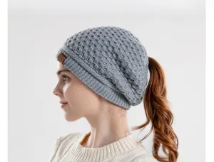 Detail of grey waffle knit hat with ponytail hole and leather logo patch