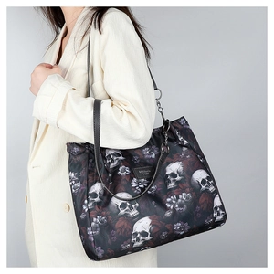 Detail of black tote bag with skull and purple floral print featuring metal chain straps