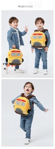 Detail shot of plush yellow school bus backpack featuring STOP sign and 3D wheels