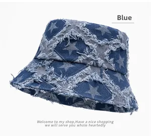 Detail of frayed star pattern on blue denim bucket hat with distressed edges