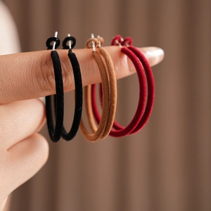 Detailed close-up of three pairs of flocked hoop earrings in black brown and red colors