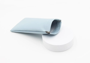 Close-up of light blue PU leather pouch with automatic spring metal closure on pedestal