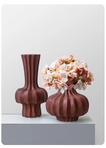 Detail of modern ribbed ceramic vases in terracotta brown with elegant matte finish texture