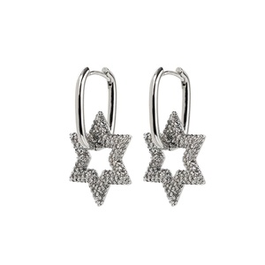 Détail de boucles d'oreilles créoles argentées avec breloques étoiles en zircons sertis
