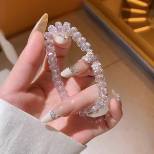 Vue détaillée du bracelet en perles de cristal irisées avec pendentif lotus en métal