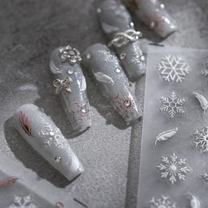 3D winter snowflake nail art stickers with metallic bows and rhinestones on grey base
