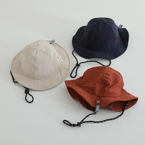 Flat lay of quick-dry bucket hats in beige, navy and rust with adjustable windproof cords