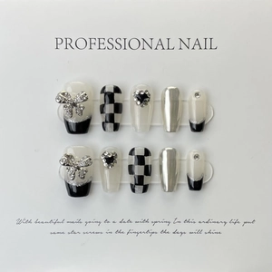 Detail of luxury press-on nails featuring 3D silver bows and black checkered patterns
