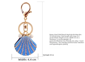 Detailed close-up of blue shell keychain with rhinestones and white pearl charms