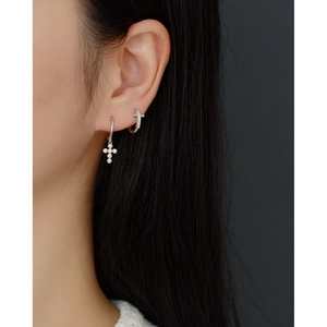 Close-up of S925 sterling silver hoop earrings with sparkling diamond cross charms on model
