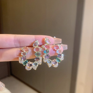 Close-up of luxury gold-plated earrings with colorful oval zircon gemstones