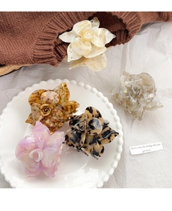 Detailed close-up of rose flower hair claws in various elegant acetate finishes