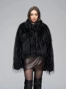 Detailed close-up of thick black faux fur coat texture with plush long-haired finish
