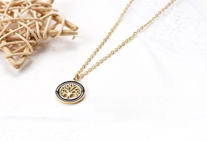 Detailed view of the gold Tree of Life pendant with black enamel inlay and fine chain