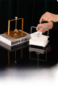 Detail of luxury metal square napkin holder with crystal weighted arm in gold and silver