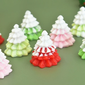 Detailed view of miniature resin Christmas trees in red green and pink for DIY decor