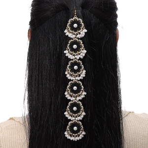 Dettaglio della catena per capelli vintage con fiori, gemme nere e perle su metallo dorato