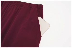 Close-up of wine red sport pants featuring elastic waistband and large side pocket with phone