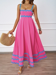 Detail of rose red maxi dress featuring blue wavy ribbon trim and summer straw bag accessory
