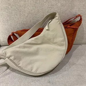 Minimalist nylon crescent crossbody bags in cream and caramel with adjustable straps