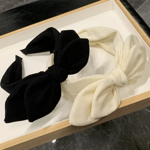 Detail of black and cream textured fabric headbands with oversized bow design