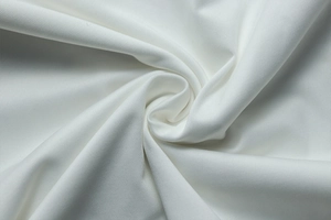 Détail macro du tissu sergé blanc avec des plis drapés doux pour ensemble de jupe