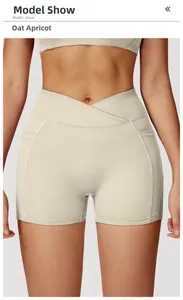 Detail of high-waisted yoga shorts in oat apricot with a cross-waist design on a model