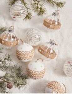 Detail of Christmas tree ornaments with white lace, pearls, and burlap on faux snow