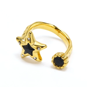 Close-up of gold star ring featuring black gemstones and sparkling white crystals