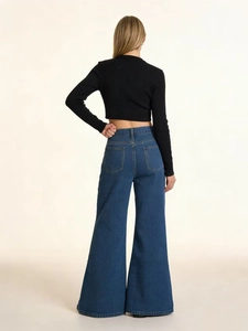 High-waist washed flare jeans with black long-sleeved crop top shown from back view
