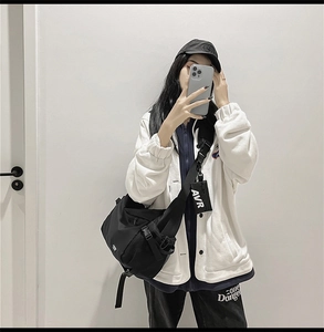 Detail view of black functional crossbody bag with a small AVR logo pouch on strap