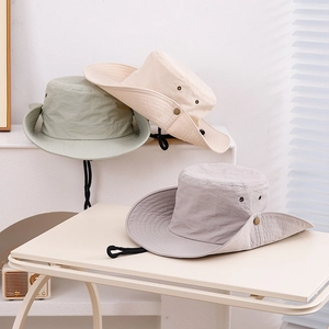 Détail de trois chapeaux de soleil à séchage rapide en vert, beige et gris avec cordons