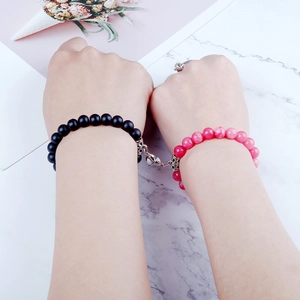Detail showing two natural stone beaded bracelets connected by a heart magnetic clasp