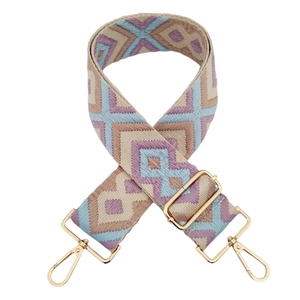 Macro detail of diamond jacquard woven bag strap with golden metal lobster clasps