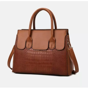 Front detail of brown satchel showing plain and crocodile texture leather stitching