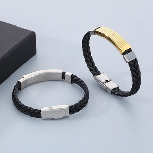 Macro detail of braided leather bracelets with stainless steel Lord’s Prayer engraving