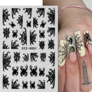 Detail of Halloween nail art stickers with black spider and web patterns on white backing