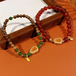 Detail of Chinese style beaded bracelets with carnelian, jasper, and golden gourd charms