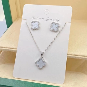 Detail view of silver clover jewelry set with mother of pearl and paved crystal accents