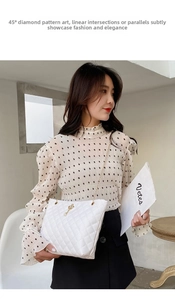 Quilted white tote bag with pearl crown pendant and chain strap worn by a female model