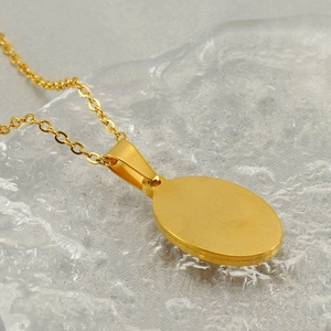 Polished gold stainless steel oval pendant necklace shown from a sleek back view