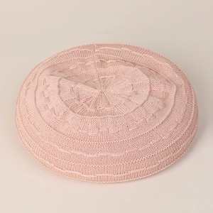 Detailed view of pink knitted beret featuring delicate wave texture and soft yarn